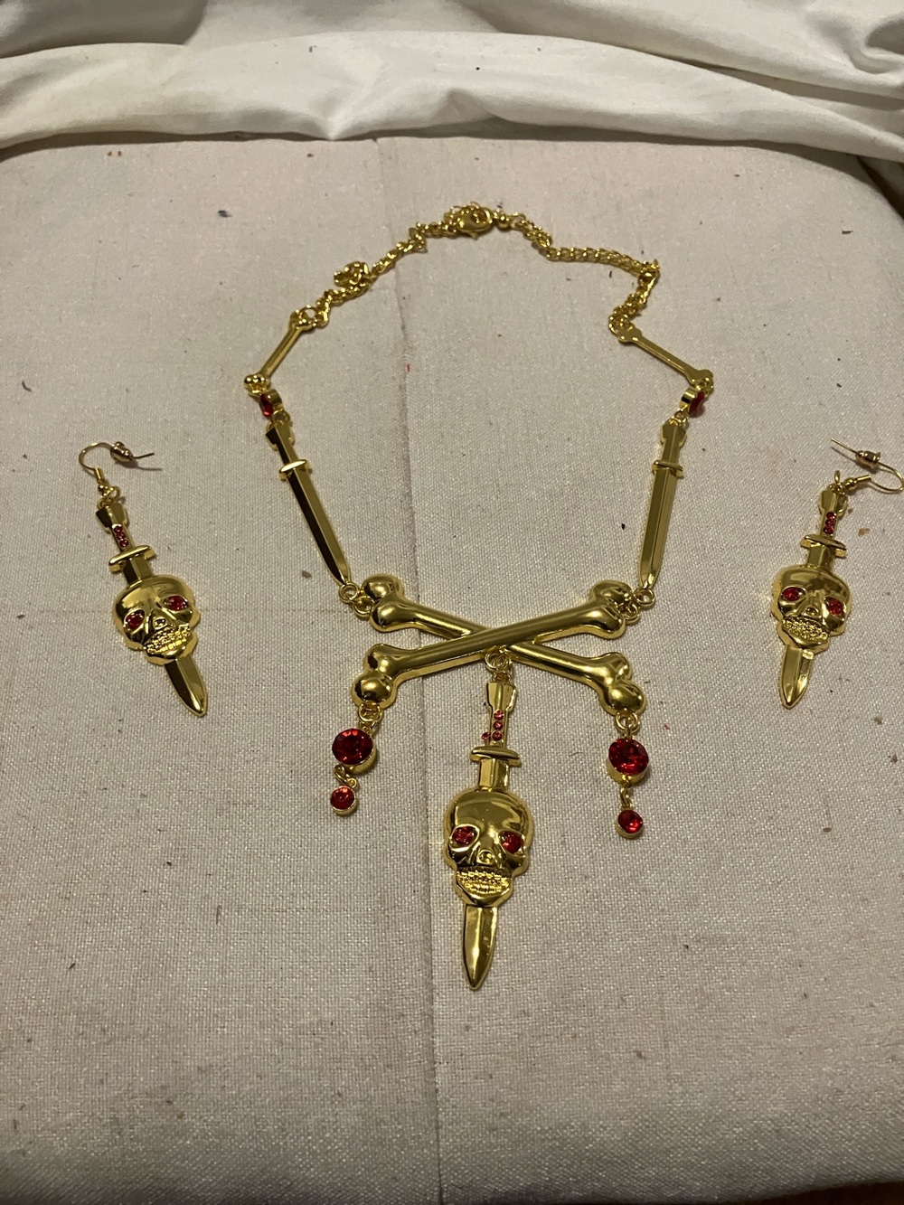 Like new. Set of 3 pieces.  Gold plate. 20” Skull necklace with ruby red stones